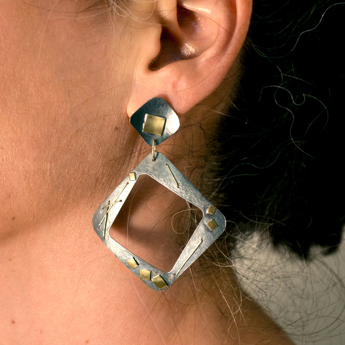 Suzanne Schwartz wearing Interwoven Square Hoop Earrings
